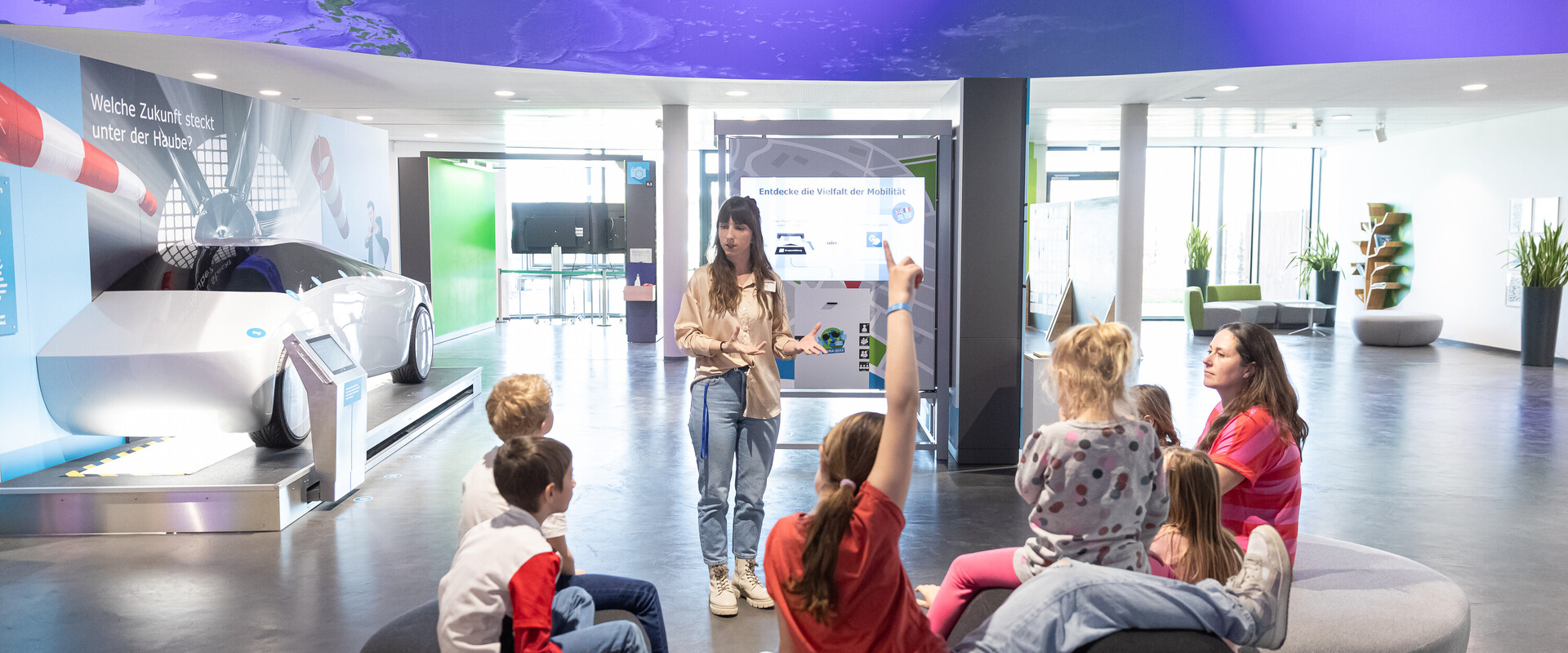 Besucherbetreuuerin und Kindergruppe bei F&uuml;hrung in der Ausstellung.