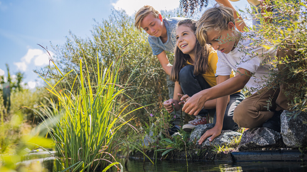Gruppe Jugendlicher am Teich der Klima Arena