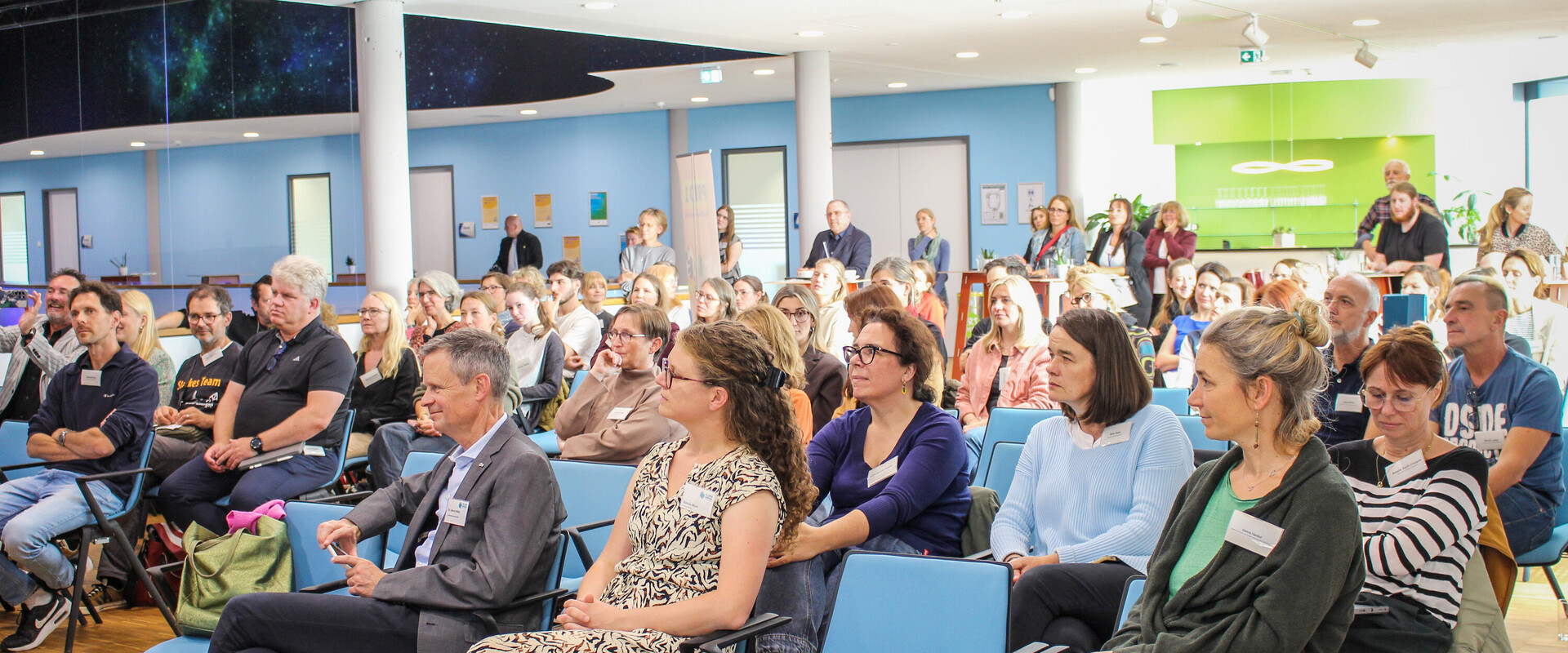Blick aufs Publikum in Stuhlreihen bei einer Veranstaltung.